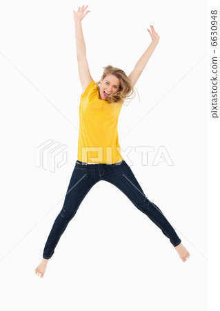 Young blonde woman in yellow shirt jumping Young blonde woman in yellow shirt jumping 6630948