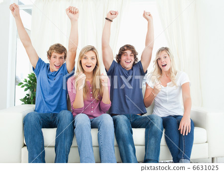 Friends celebrate together while sitting and looking a the camer 6631025