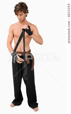Martial arts fighter bandaging his hand 6631054
