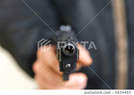 A man holding a handgun 6634483