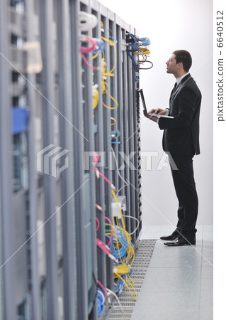 businessman with laptop in network server room businessman with laptop in network server room 6640512