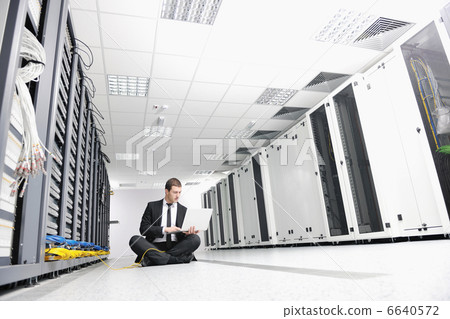 businessman with laptop in network server room businessman with laptop in network server room 6640572