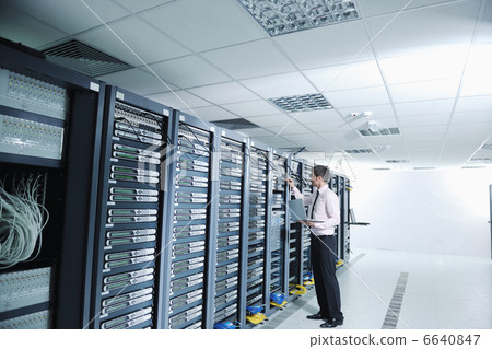 businessman with laptop in network server room businessman with laptop in network server room 6640847
