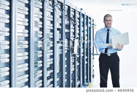 businessman with laptop in network server room 6640956