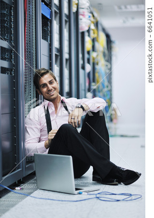 businessman with laptop in network server room businessman with laptop in network server room 6641051