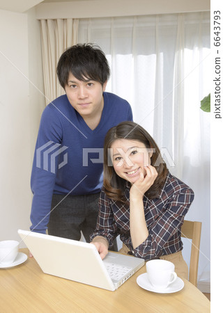 看一台計算機的一對年輕夫婦在餐廳 6643793