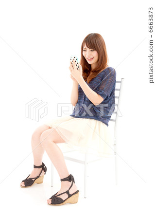 A young woman who write mail happily on a smartphone 6663873