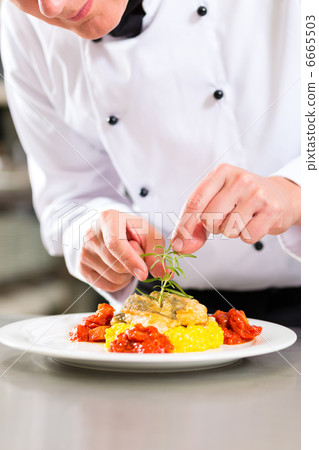 Female Chef in restaurant kitchen cooking 6665503