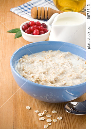 bowl of oatmeal  with milk on wood 6678843