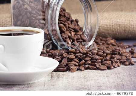 cup full of coffee and glass pot with beans on sack cup full of coffee and glass pot with beans on sack 6679578