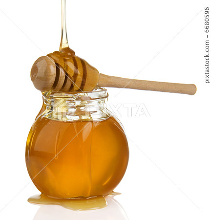 glass pot full of honey and stick on white glass pot full of honey and stick on white 6680596