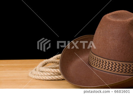 brown cowboy hat and rope isolated on black 6681601