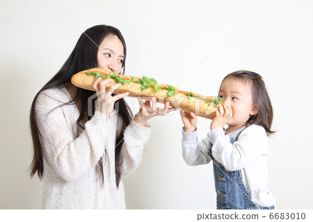 Parent and child eating baguet sandwich Parent and child eating baguet sandwich 6683010