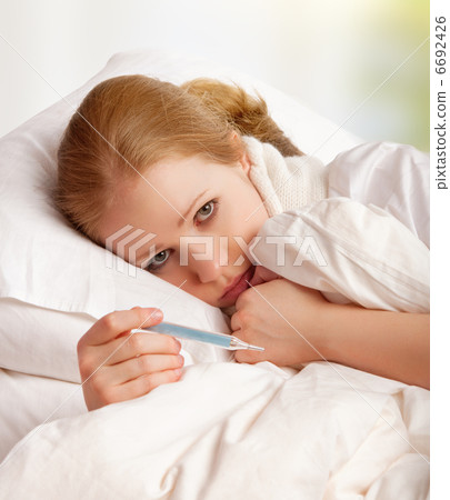 Woman with thermometer sick colds, flu, fever in bed 6692426
