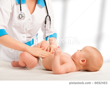 Doctor examines, massaging baby tummy Doctor examines, massaging baby tummy 6692483