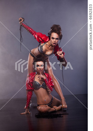 Lewdness. Two Flirty Woman in Erotic Pose Enjoying Music. Glamor Lewdness. Two Flirty Woman in Erotic Pose Enjoying Music. Glamor 6692833