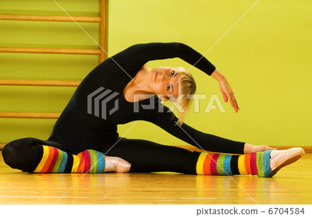 Ballet dancer doing stretching exercise on a floor Ballet dancer doing stretching exercise on a floor 6704584