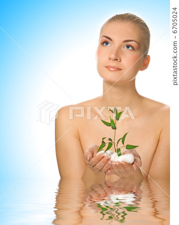Beautiful young woman with small plant standing in water Beautiful young woman with small plant standing in water 6705024