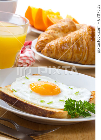breakfast with fried egg, juice and croissant 6707515