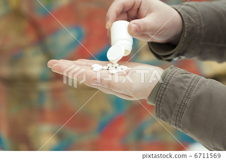 有藥物的一個人在牆壁背景的手上 6711569