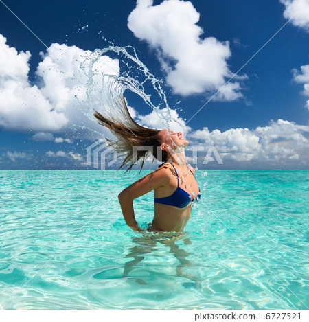 Woman splashing water with hair in the ocean Woman splashing water with hair in the ocean 6727521