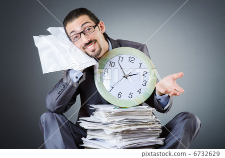 Man with clock and pile of papers 6732629