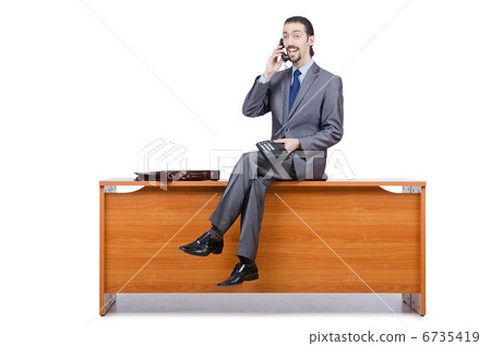 Businessman sitting on desk and speaking phone 6735419
