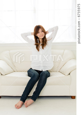 A woman relaxing on a sofa A woman relaxing on a sofa 6735975