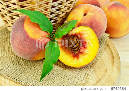 Peaches with leaves and a basket on board Peaches with leaves and a basket on board 6749584