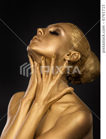 Coloring. Gilt. Golden Plated Woman's Face. Art concept. Gilded Body. Focus on her hands 6765715