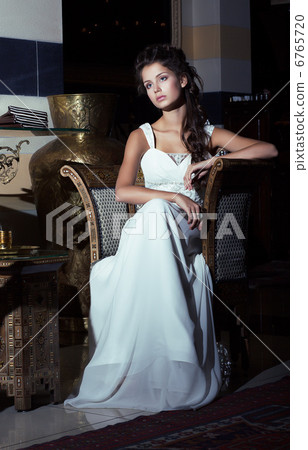 Wedding Style. Aristocratic Bride sitting in White Dress. Restaurant Interior 6765720