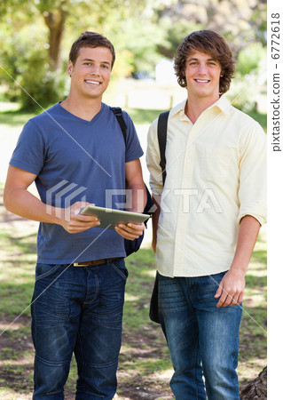 Portrait of two smiling male students with a touch pad Portrait of two smiling male students with a touch pad 6772618