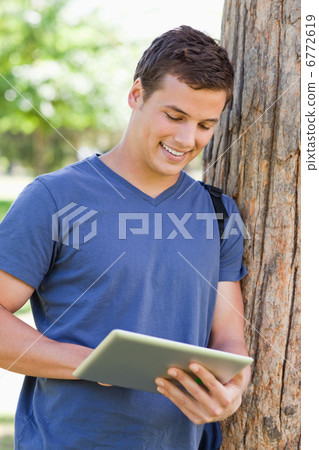 Close-up of a young man using a touch pad Close-up of a young man using a touch pad 6772619