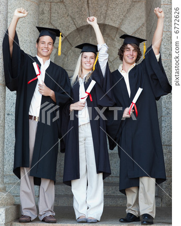 Smiling graduates raising arm 6772626