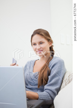 Woman sitting while using a computer Woman sitting while using a computer 6772744