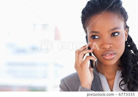 Young employee looking towards the side while talking on the pho 6773335