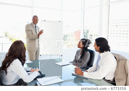 Businessman giving a presentation in front of his colleagues 6773358