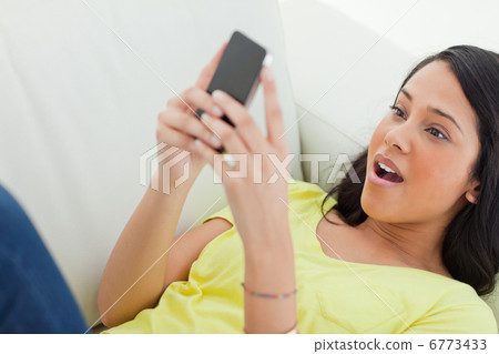 Close-up of a surprised Latino looking her smartphone Close-up of a surprised Latino looking her smartphone 6773433