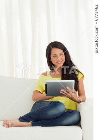 Beautiful Latino smiling while using a touch pad Beautiful Latino smiling while using a touch pad 6773462