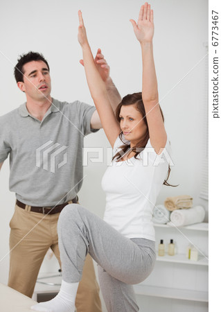 Woman standing while doing her exercises Woman standing while doing her exercises 6773467