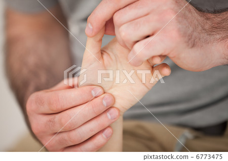 Physiotherapist palpating the fingers of a patient Physiotherapist palpating the fingers of a patient 6773475