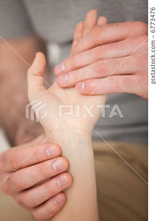 Doctor looking at the wrist of a patient Doctor looking at the wrist of a patient 6773476