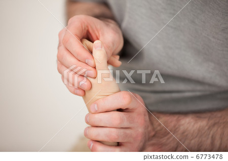 Doctor manipulating the fingers of a patient Doctor manipulating the fingers of a patient 6773478