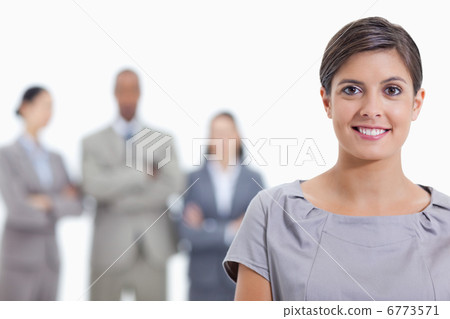 Big close-up of a businesswoman smiling and a team in background 6773571