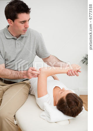 Osteopath stretching the arm of his patient Osteopath stretching the arm of his patient 6773588