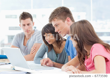 A group all looking into the laptop A group all looking into the laptop 6773590