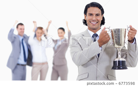Close-up of a businessman smiling and holding a cup with people Close-up of a businessman smiling and holding a cup with people 6773598