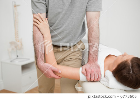 Physiotherapist pressing the shoulder of a woman Physiotherapist pressing the shoulder of a woman 6773605