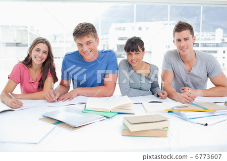 Four smiling students look up into the camera Four smiling students look up into the camera 6773607