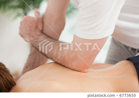 Doctor massaging his back of his patient while using his elbow Doctor massaging his back of his patient while using his elbow 6773650
